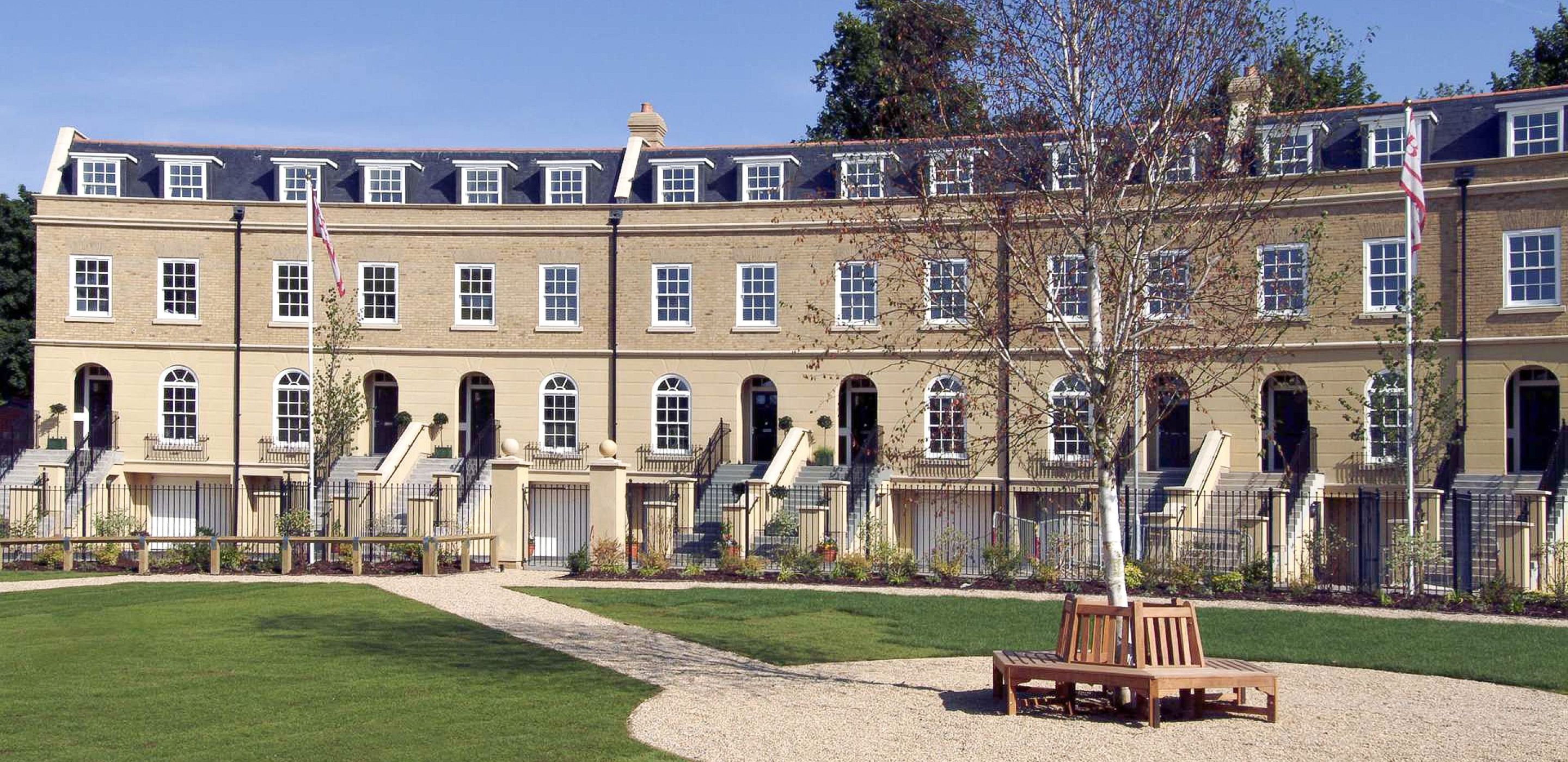 Block of houses with green field in front of them