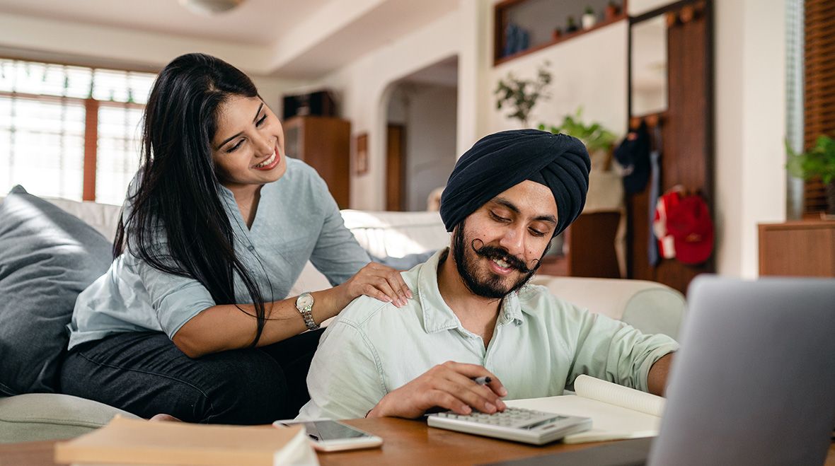 Couple smiling at how much they've saved by cutting service charge costs