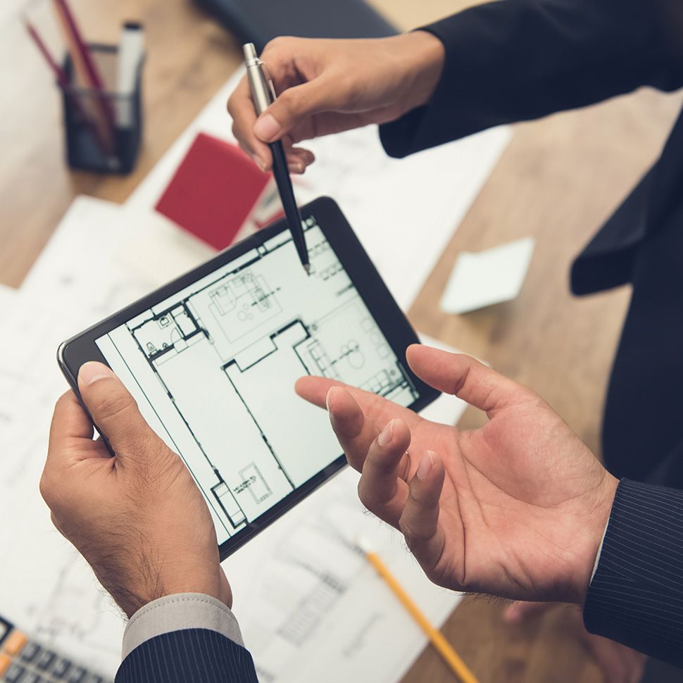 A property developer discussing blueprints with Mandeville employee over potential management